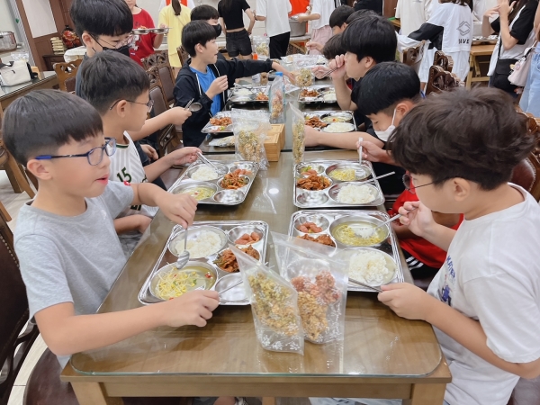 의령군 친환경쌀로 지은 밥을 먹고 있는 학생들의 모습.